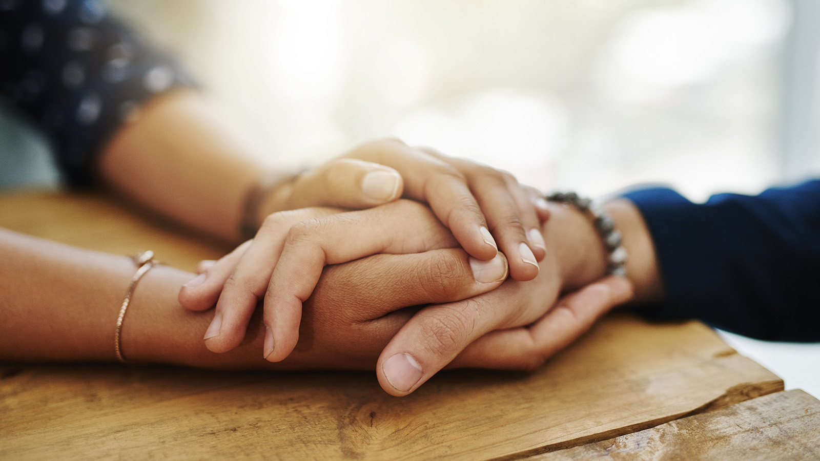 Closeup shot of two unrecognizable people holding hands in comfort