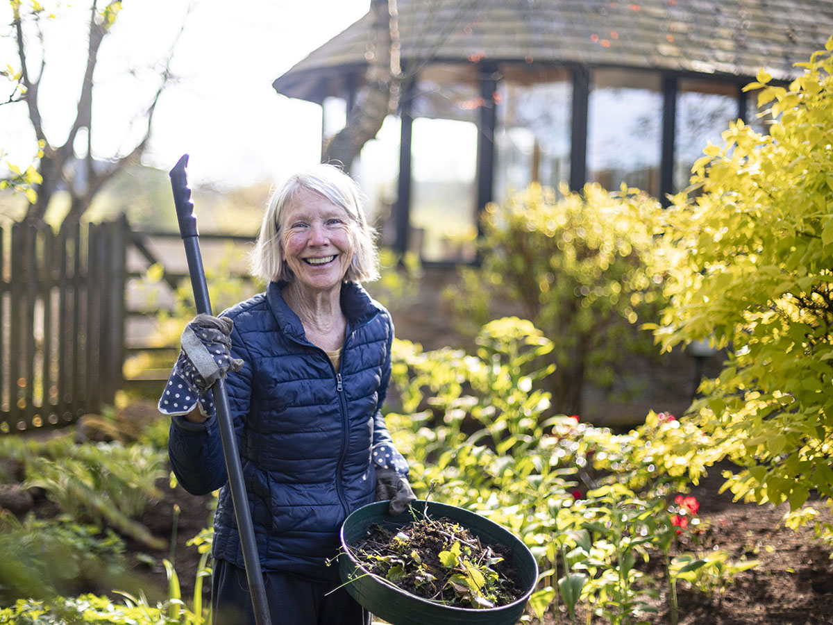 Adult female wearing blue jacket gardening