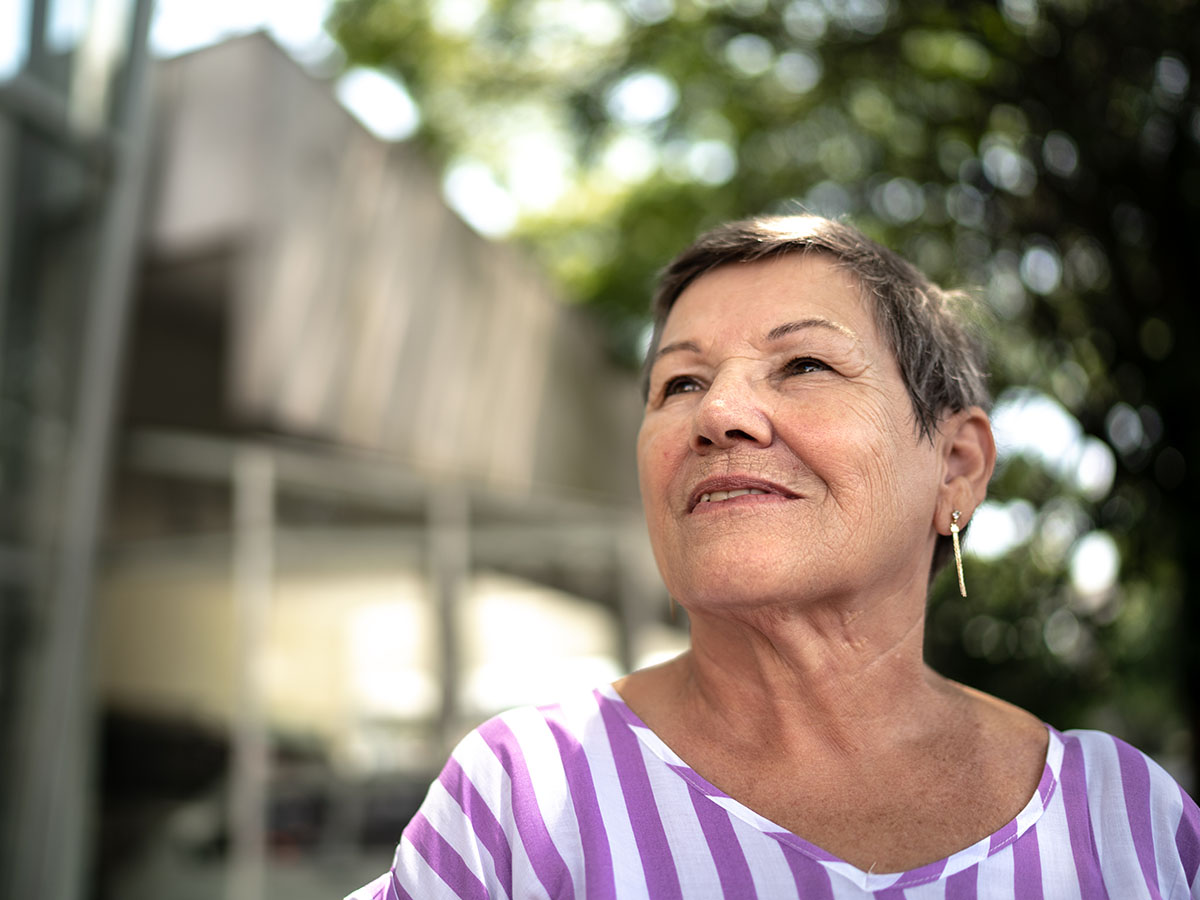 Senior female wearing striped shirt looking into distance