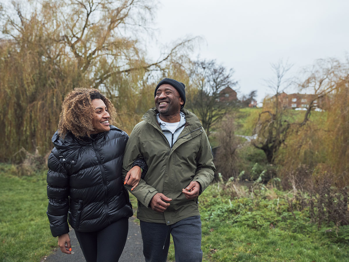 Adult couple wearing jackets walking on path