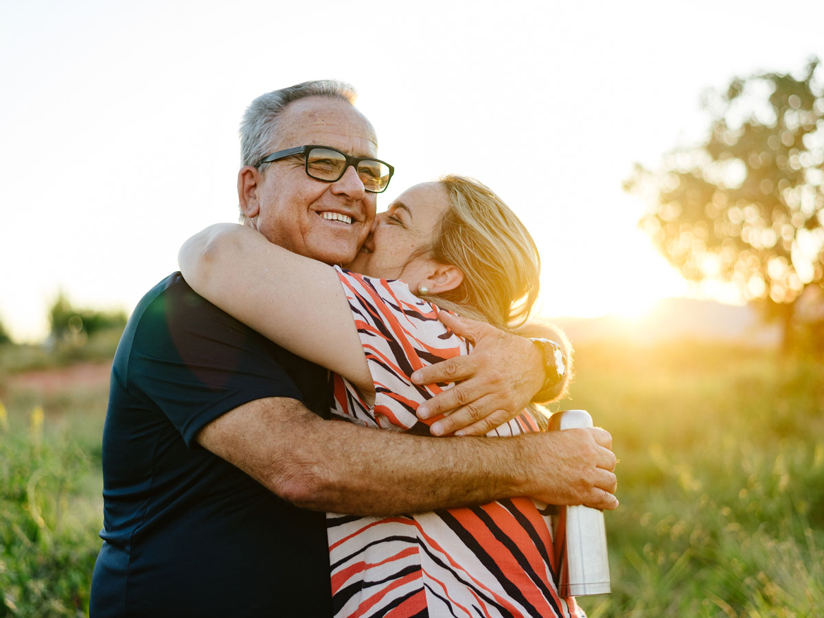 Senior couple embracing in a field.