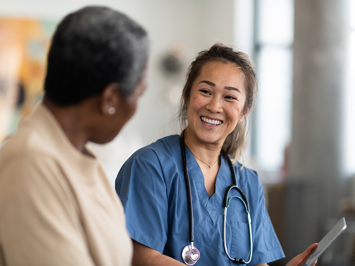 Female nurse with a stethoscope talks with her female patient