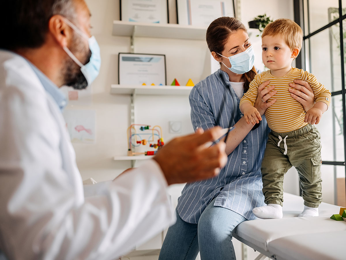 Young child with mother with pediatrician.